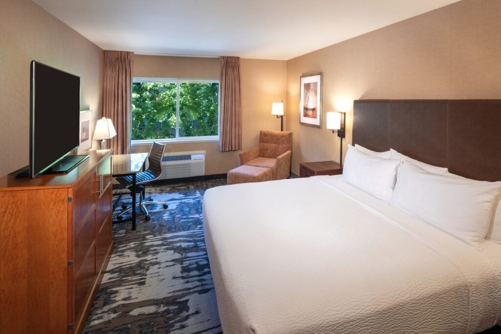 Hotel room with one king bed, window, desk and TV